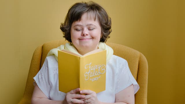 Eine junge Frau lächelt beim Lesen