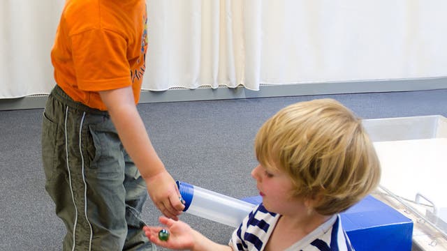Kinder teilen Murmeln nach Zusammenarbeit