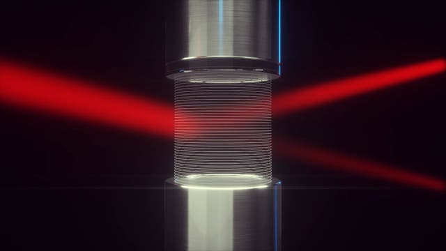 Ein Laserlichtstrahl läuft zwischen einer Lautsprecher-Reflektor-Anordnung hindurch, die ein Gitter aus Luft erzeugt