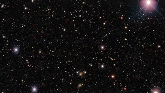 Ein Himmelsausschnitt mit zahlreichen hell leuchtenden Sternen und Galaxien