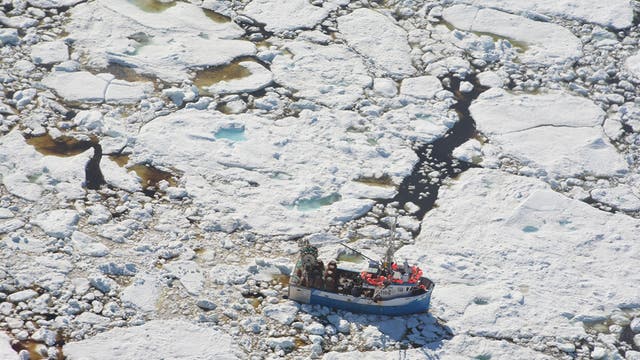 Eisschollen aus mehrjährigem Eis umgeben ein Fischerboot.