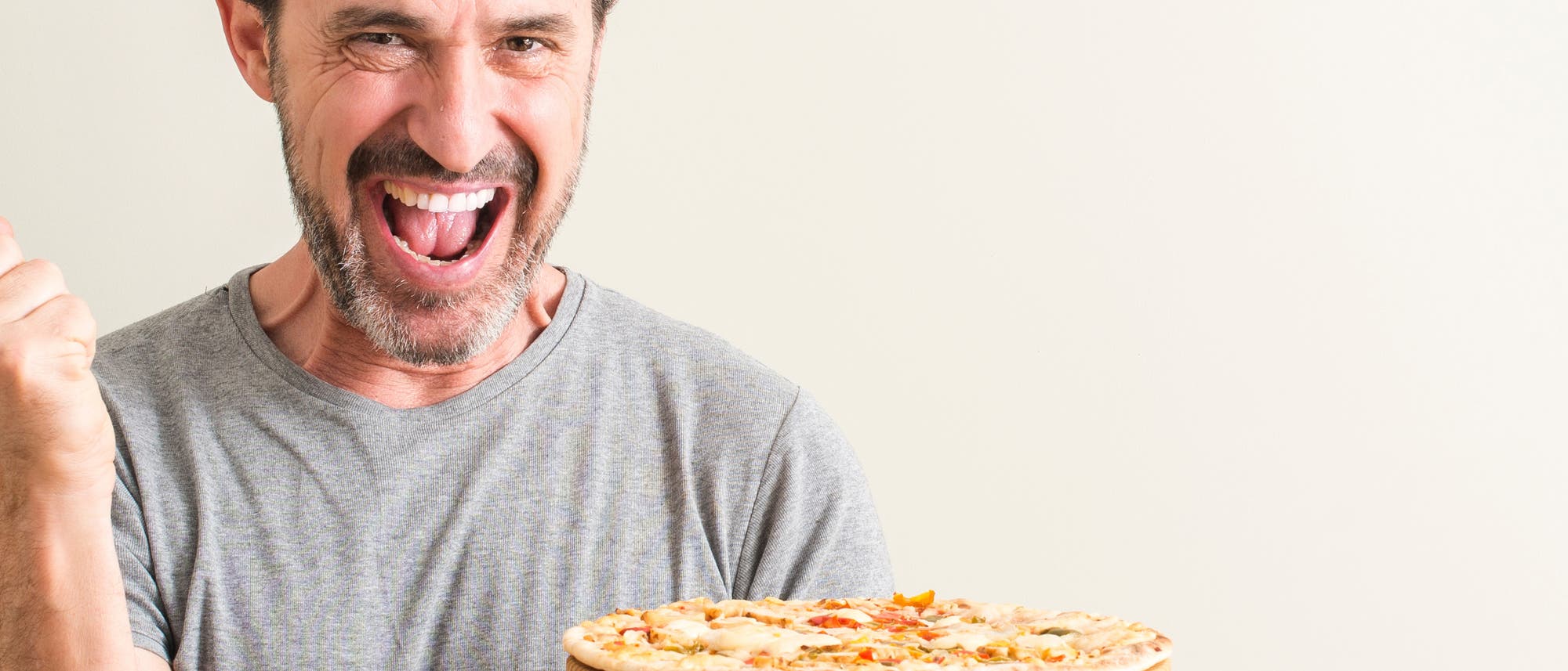 Ein Mann freut sich über die Pizza