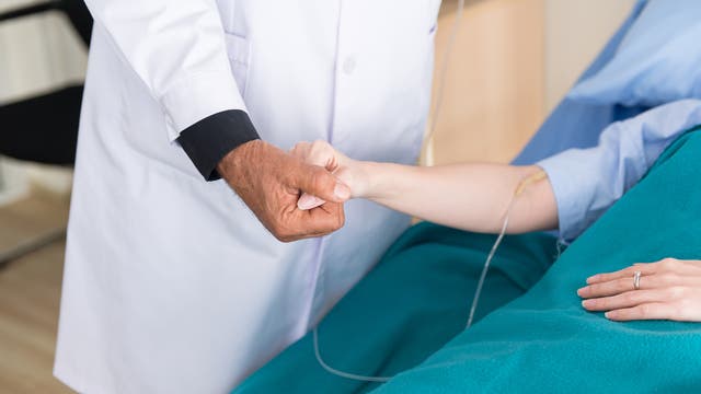Arzt hält die Hand einer Patientin