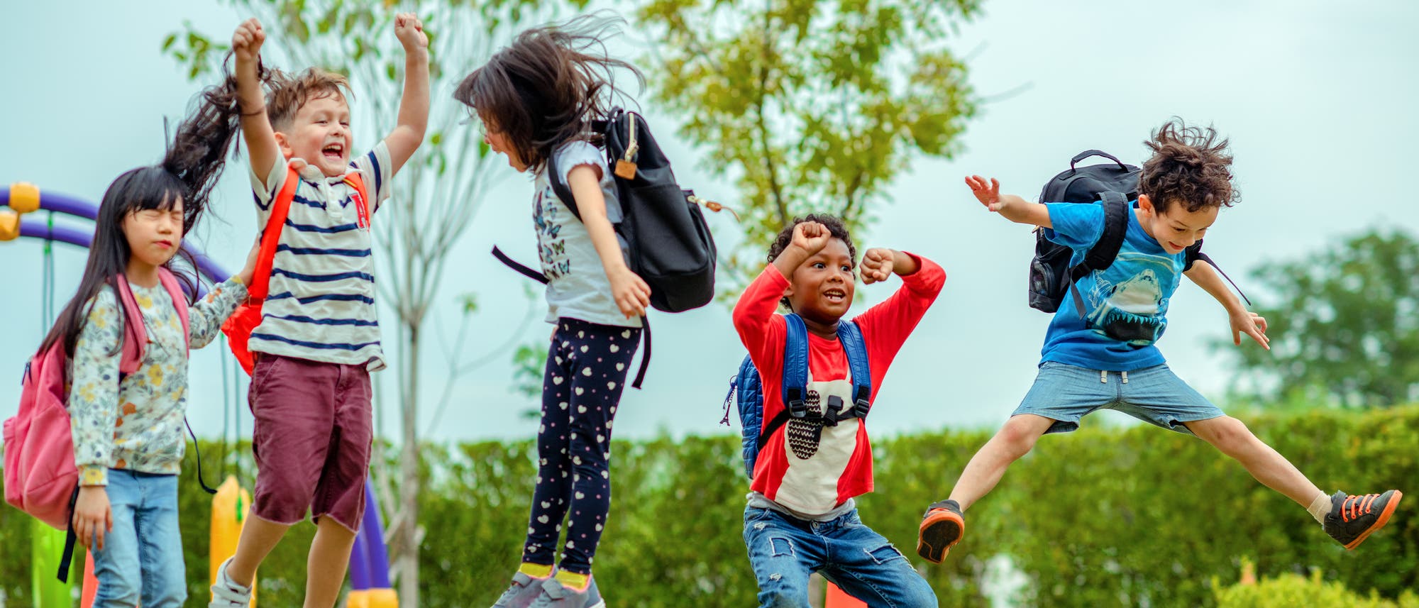 Mehrere Schulkinder beim Hüpfen auf einem Spielplatz. Mehrere Schulkinder beim Hüpfen auf einem Spielplatz.