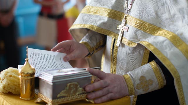 Ein Priester liest aus der Bibel 