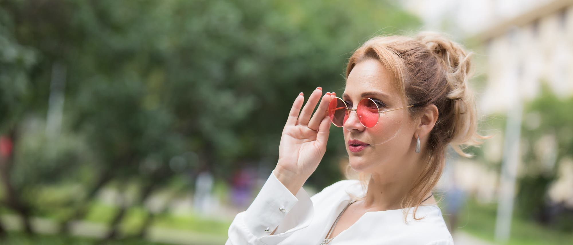 Frau blickt durch eine rosarote Brille Frau blickt durch eine rosarote Brille