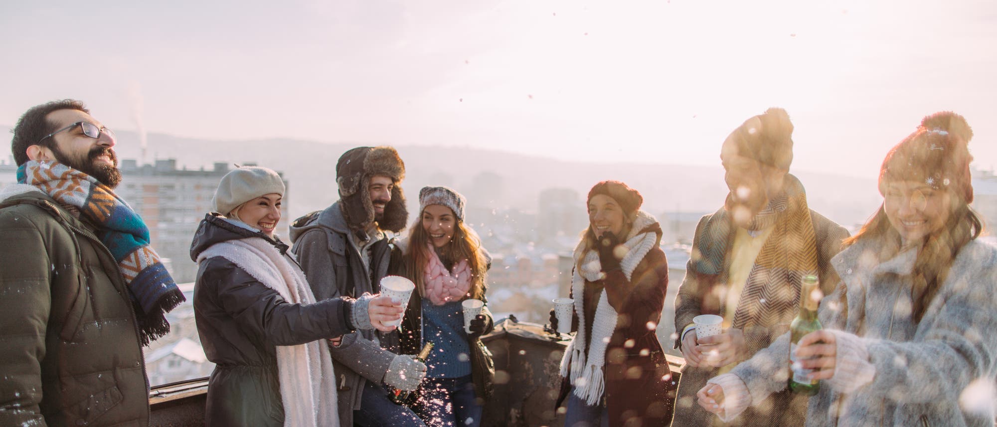Freunde feiern in der Kälte draußen auf einer Dachterrasse Freunde feiern in der Kälte draußen auf einer Dachterrasse