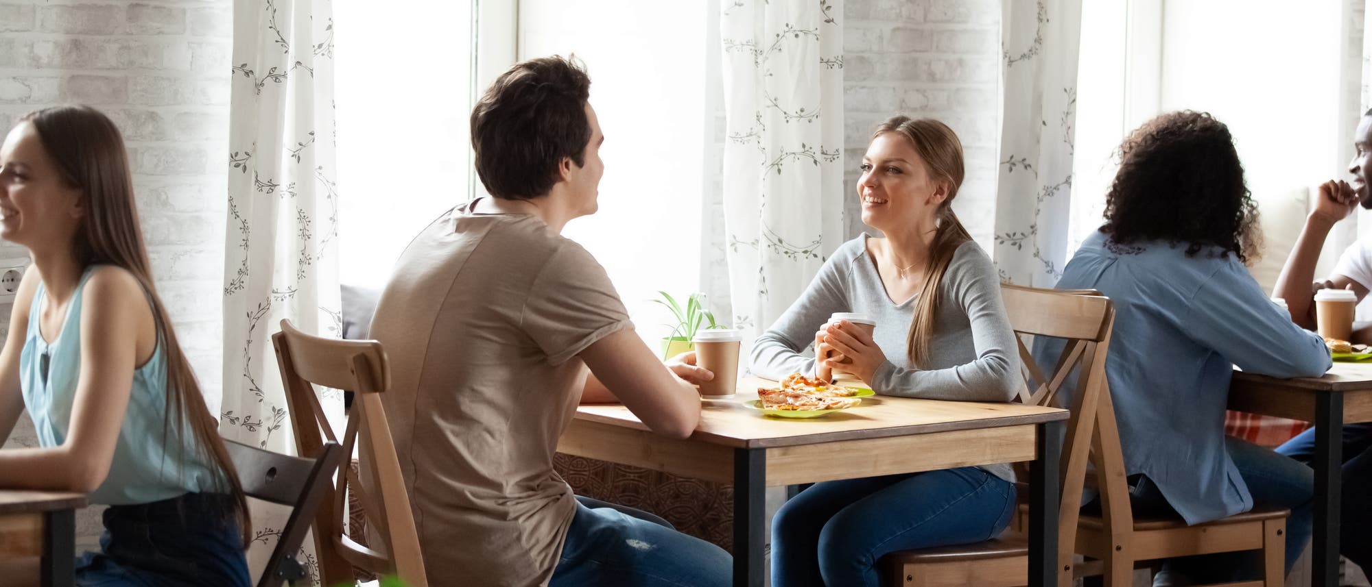 Mann und Frau sitzen im Café am Tisch und plaudern Mann und Frau sitzen im Café am Tisch und plaudern