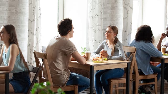 Mann und Frau sitzen im Café am Tisch und plaudern