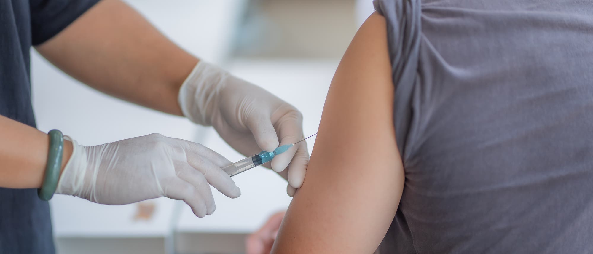 Eine Person bekommt eine Spritze in den Arm Eine Person bekommt eine Spritze in den Arm