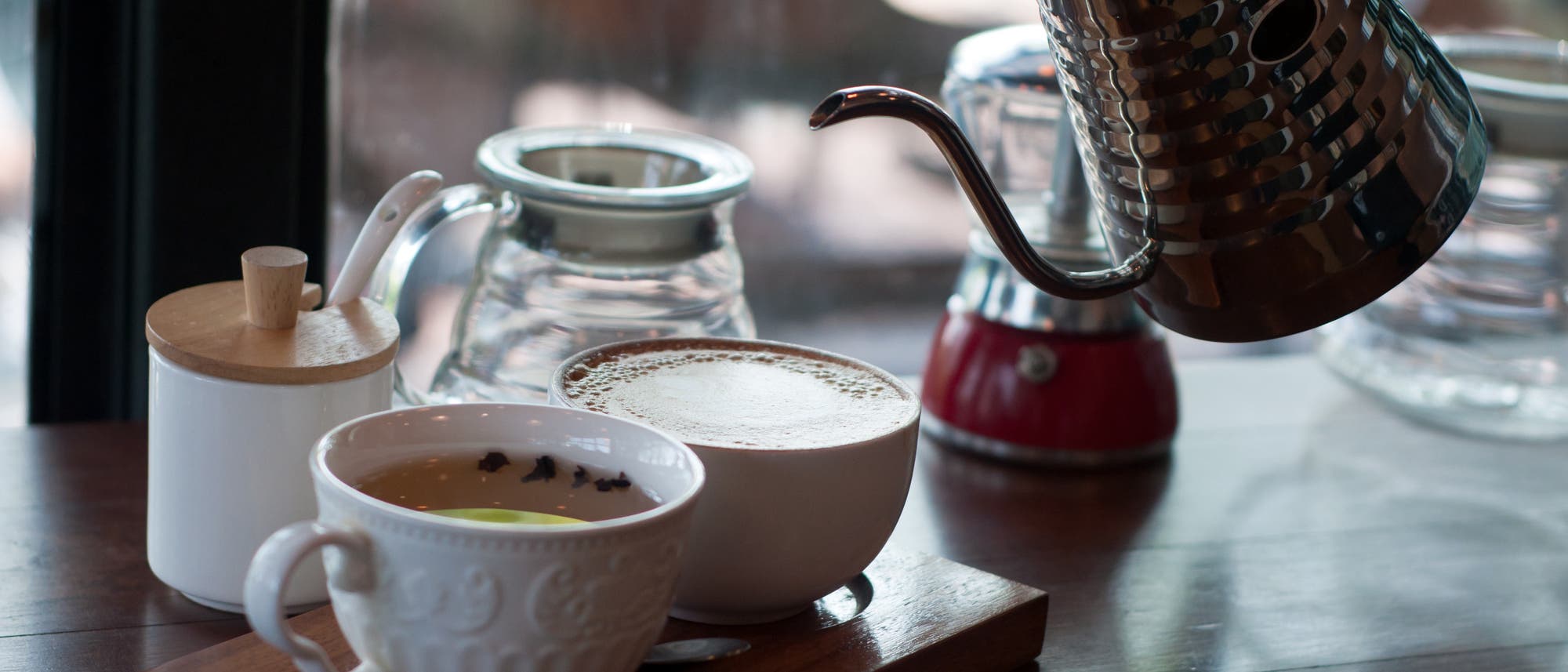 Tee und Kaffee in Tasse und Kännchen auf einem Tablett Tee und Kaffee in Tasse und Kännchen auf einem Tablett