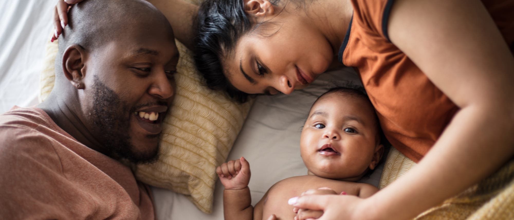 Mutter, Vater, Baby liegen glücklich miteinander auf dem Bett Mutter, Vater, Baby liegen glücklich miteinander auf dem Bett