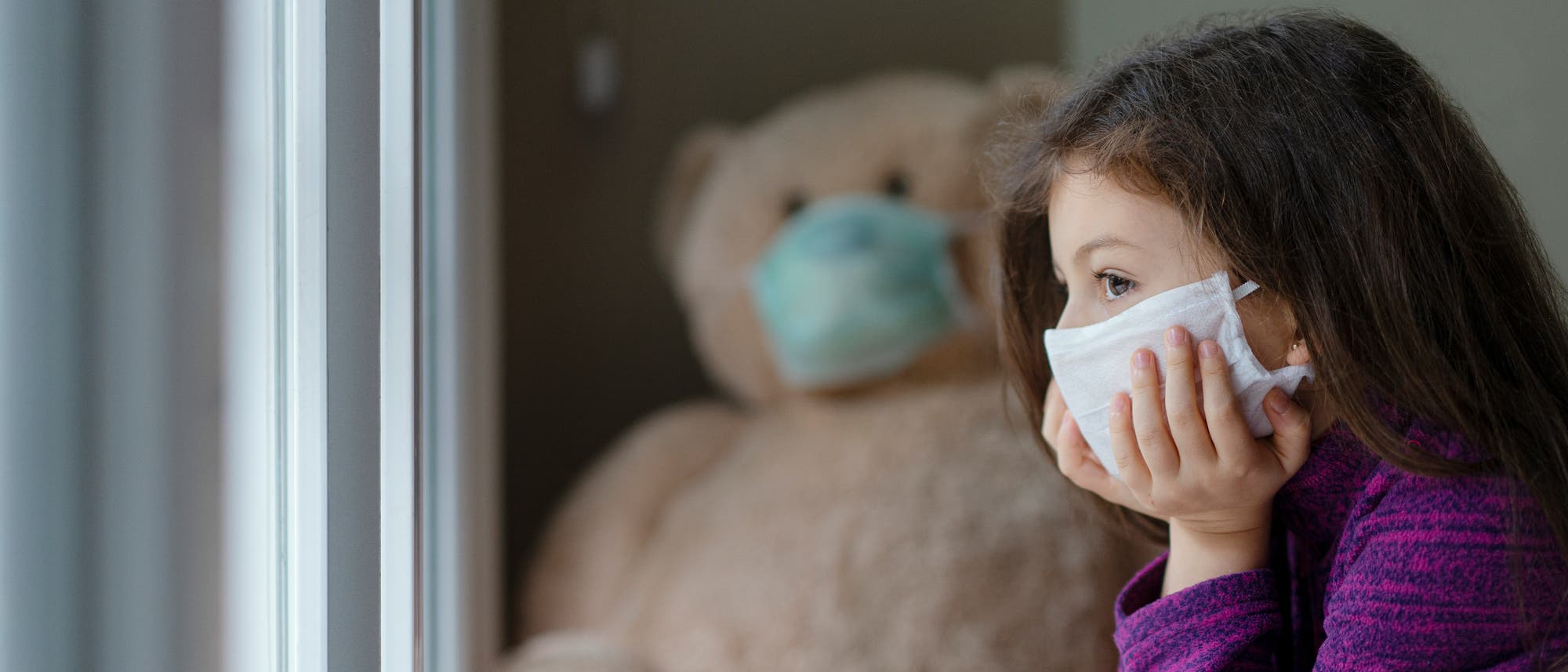 Kind und Teddy mit Maske Kind und Teddy mit Maske