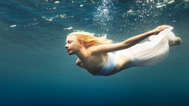Frau schwebt Unterwasser