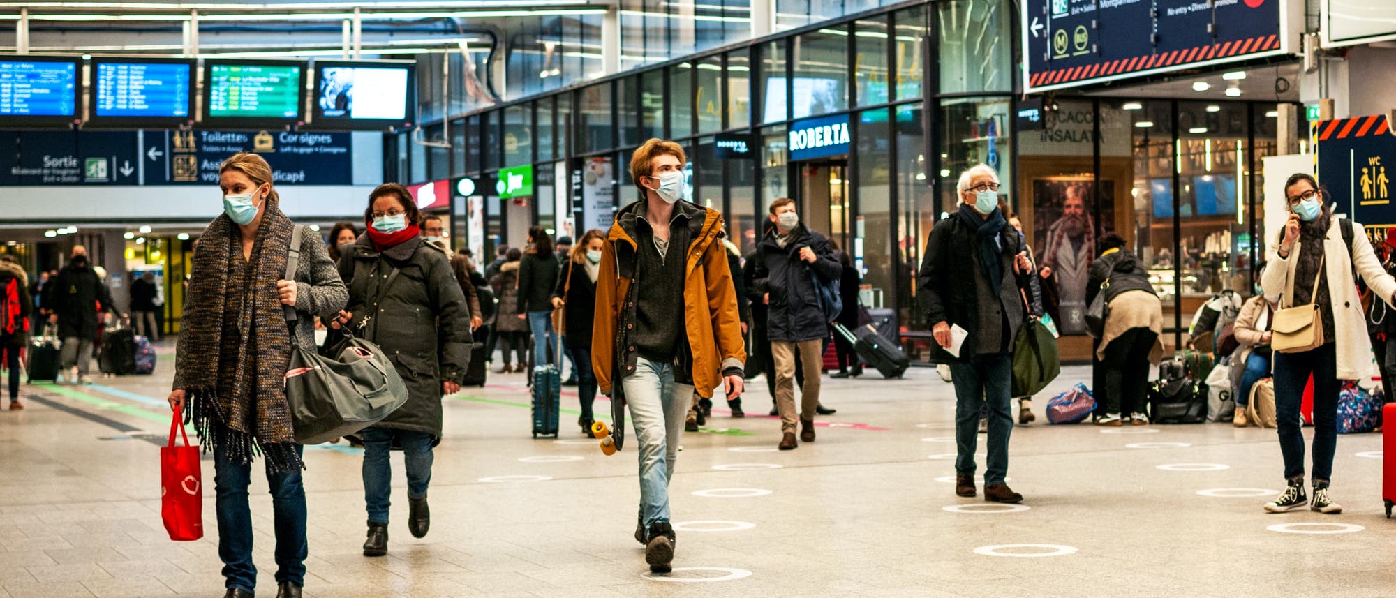 Menschen in einem Pariser Bahnhof, mit Masken vorm Gesicht Menschen in einem Pariser Bahnhof, mit Masken vorm Gesicht