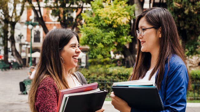 Zwei Studentinnen unterhalten sich auf dem Campus