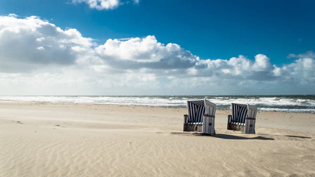 Zwei einsame Strandkörbe am endlosen Strand.