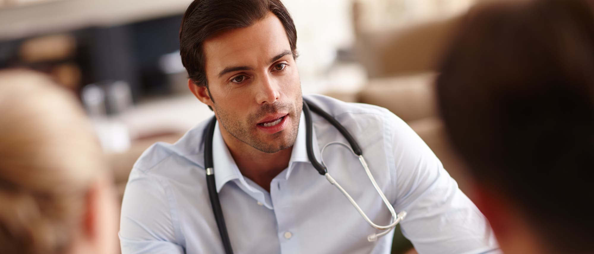 Ein Mediziner im Gespräch mit Patienten Ein Mediziner im Gespräch mit Patienten