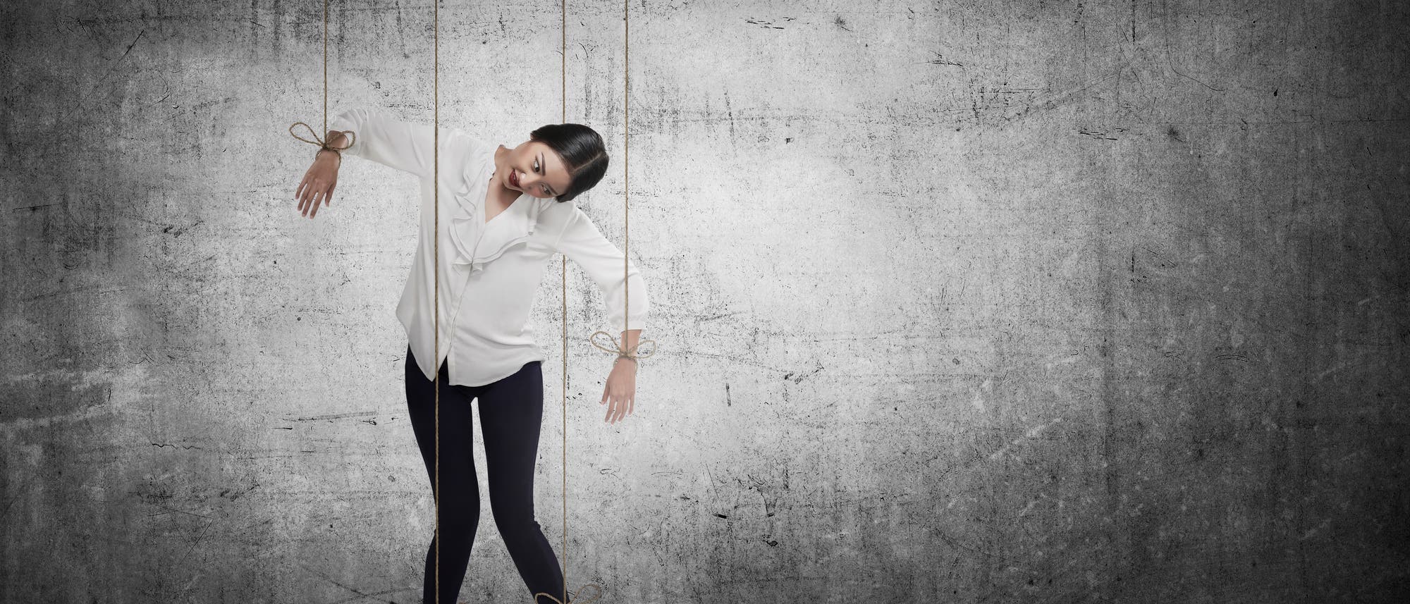 Frau hängt an Seilen, wie eine Marionette Frau hängt an Seilen, wie eine Marionette