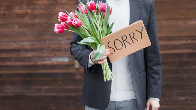 Mann mit Blumen sagt Sorry