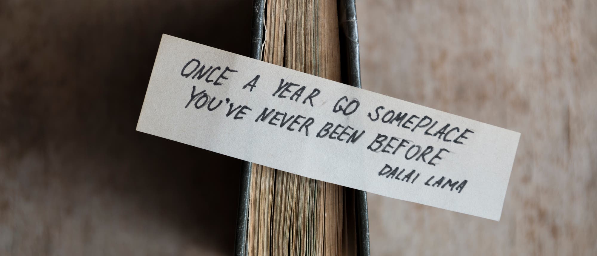 Ein Zettel mit der Aufschrift: »Once a year go someplace you've never been before.» (Dalai Lama) Ein Zettel mit der Aufschrift: »Once a year go someplace you've never been before.» (Dalai Lama)