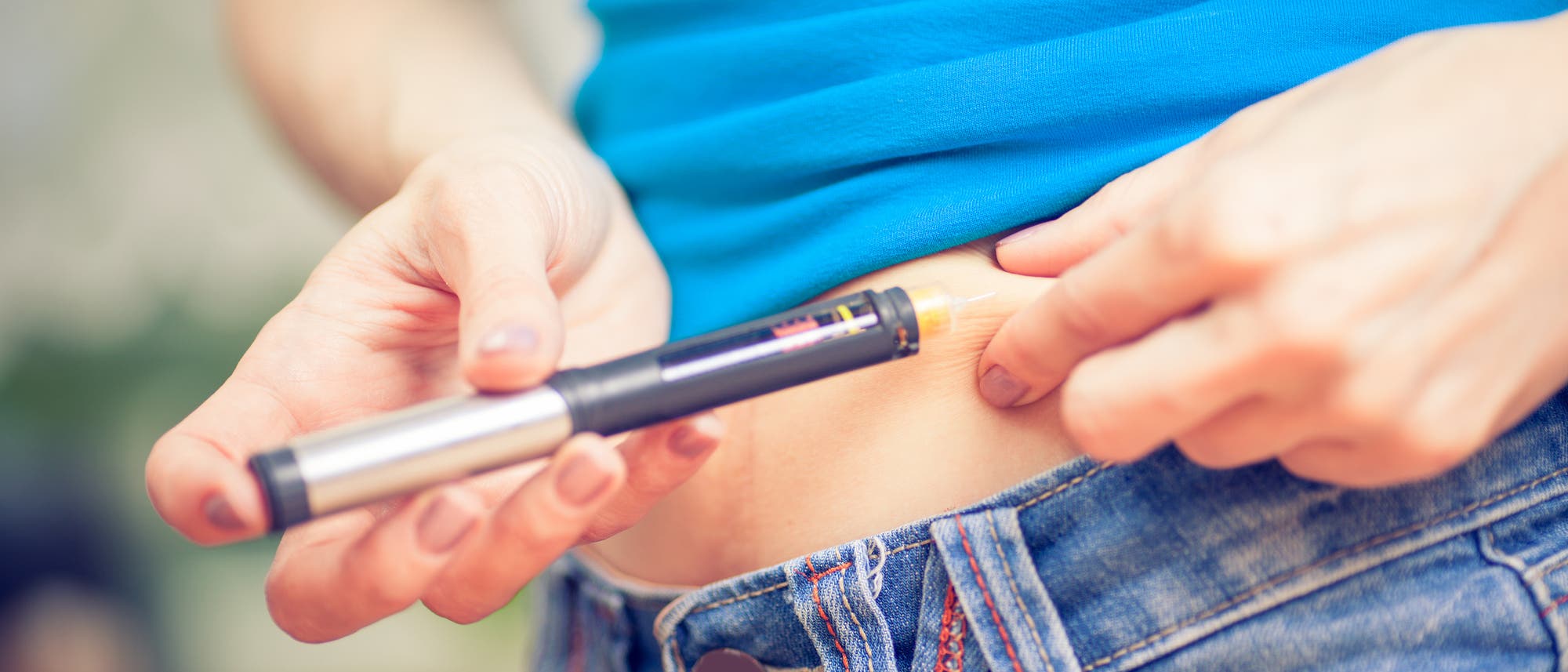 Junge Frau bei der Injektion von Insulin mit einem Pen