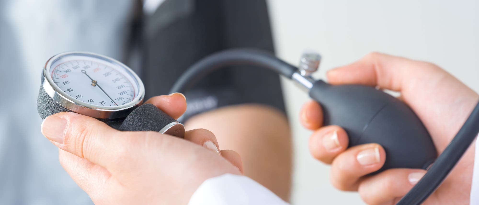 Arzt misst bei einem Patienten den Blutdruck Arzt misst bei einem Patienten den Blutdruck