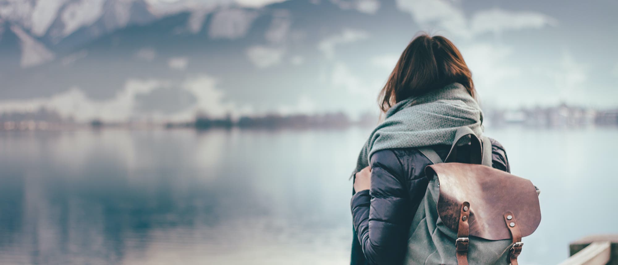 Frau blickt auf eine winterliche Seenlandschaft Frau blickt auf eine winterliche Seenlandschaft