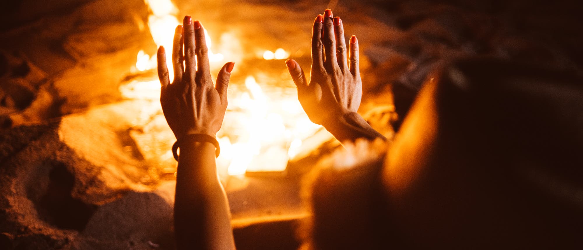 Wärmende Hände an Lagerfeuer Wärmende Hände an Lagerfeuer