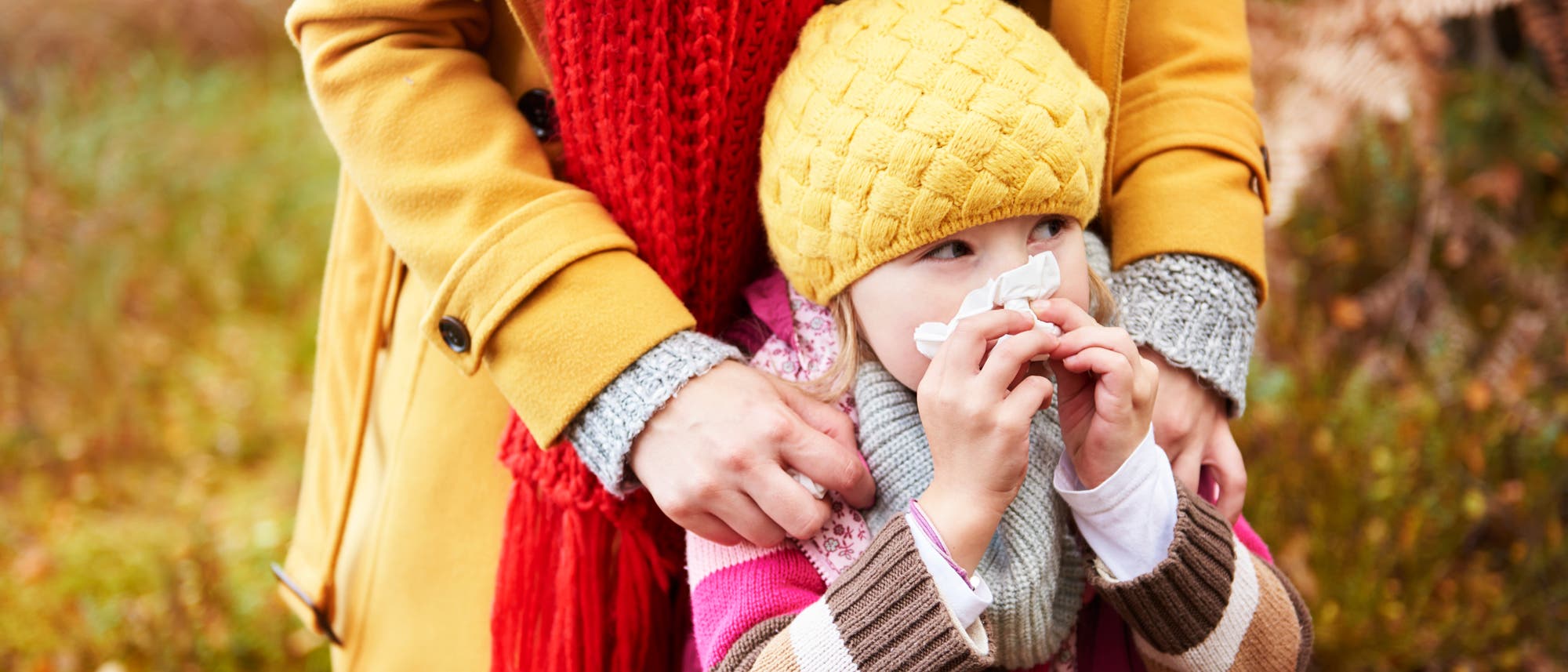 Ein Kind in Winterklamotten putzt sich das Näschen. Ein Kind in Winterklamotten putzt sich das Näschen.