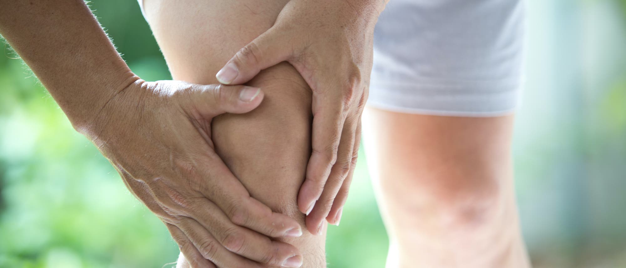 Joggender Mann hält sich ein Knie Joggender Mann hält sich ein Knie
