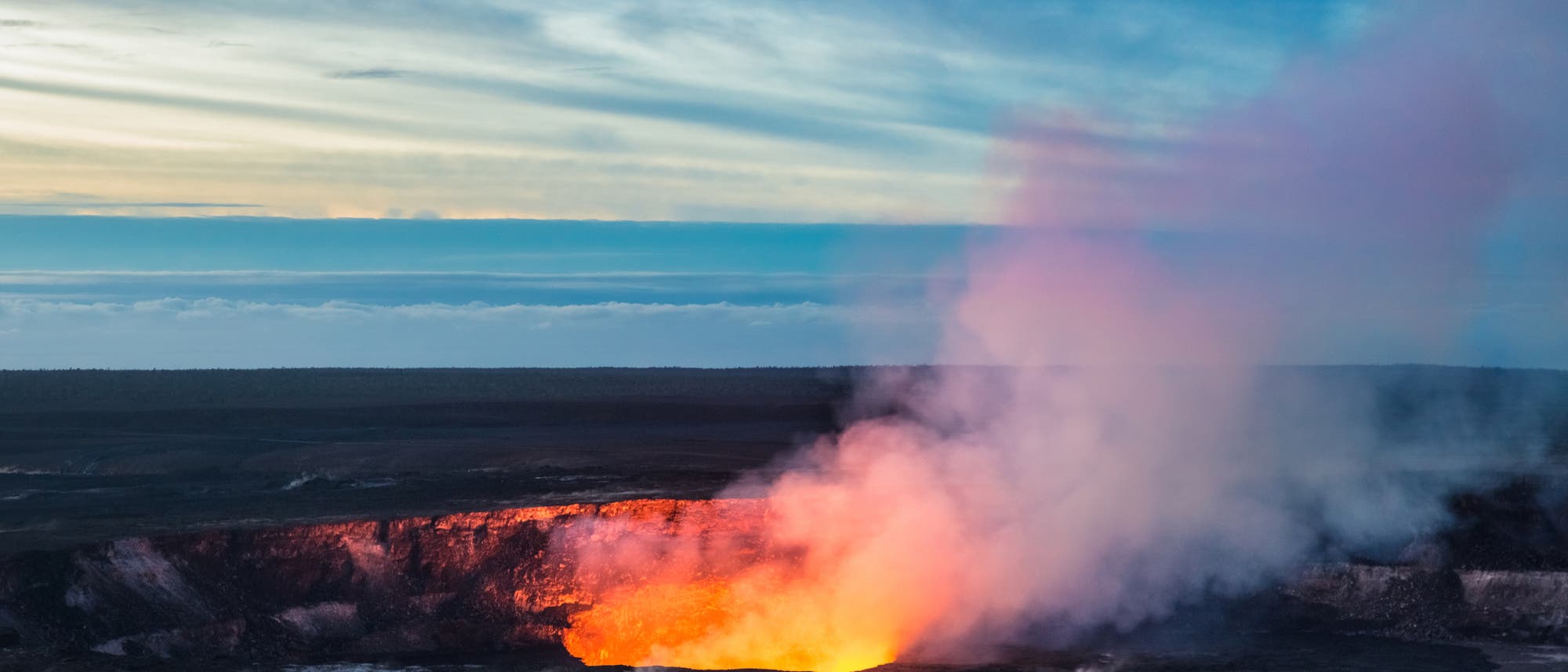 Blick auf den Gipfelkrater des Kilauea mit Lavasee, im Hintergrund Wolken. Blick auf den Gipfelkrater des Kilauea mit Lavasee, im Hintergrund Wolken.