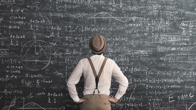 Ein Mann steht vor einer riesigen Tafel voller mathematischer Berechnungen