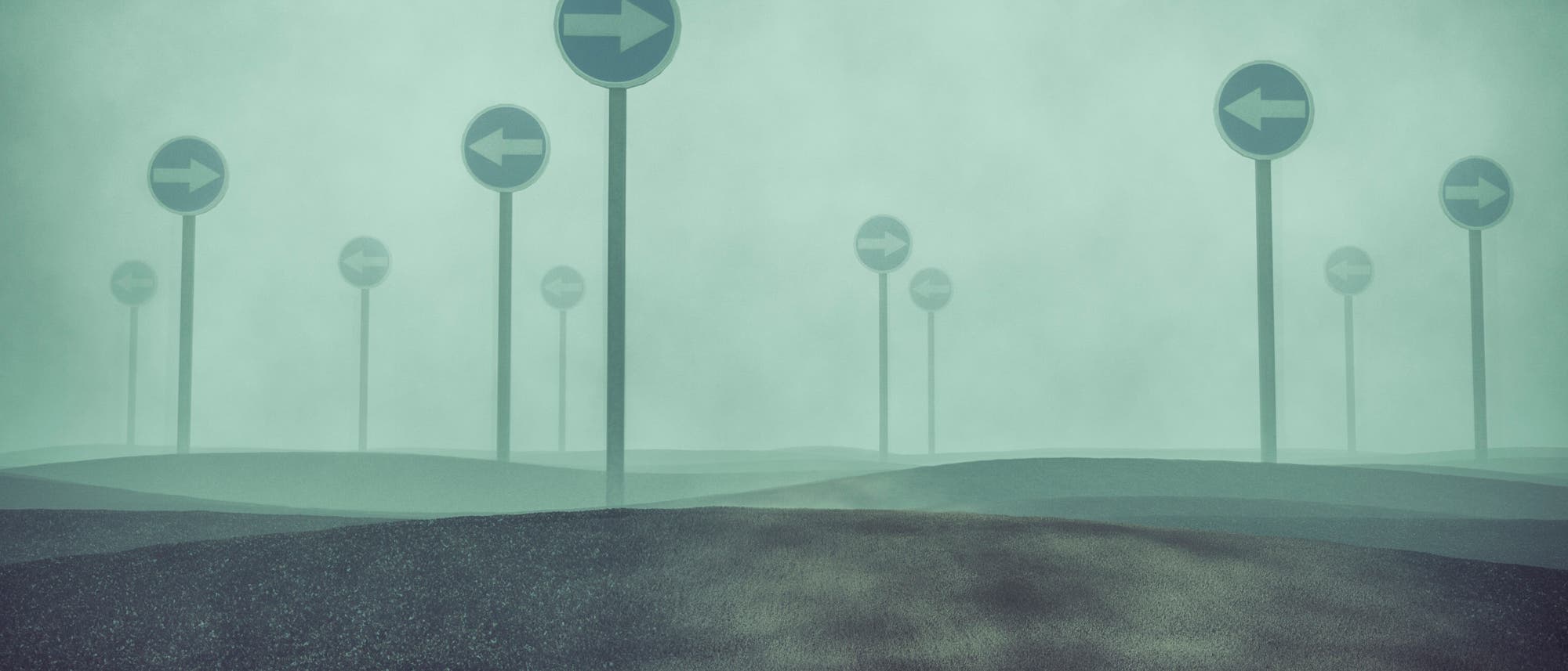Schilder im Nebel, die in verschiedene Richtungen weisen Schilder im Nebel, die in verschiedene Richtungen weisen