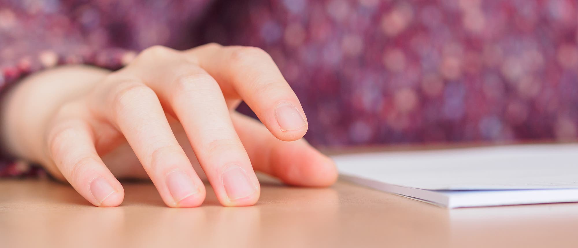 Mädchen trommelt mit dem Finger auf dem Tisch Mädchen trommelt mit dem Finger auf dem Tisch