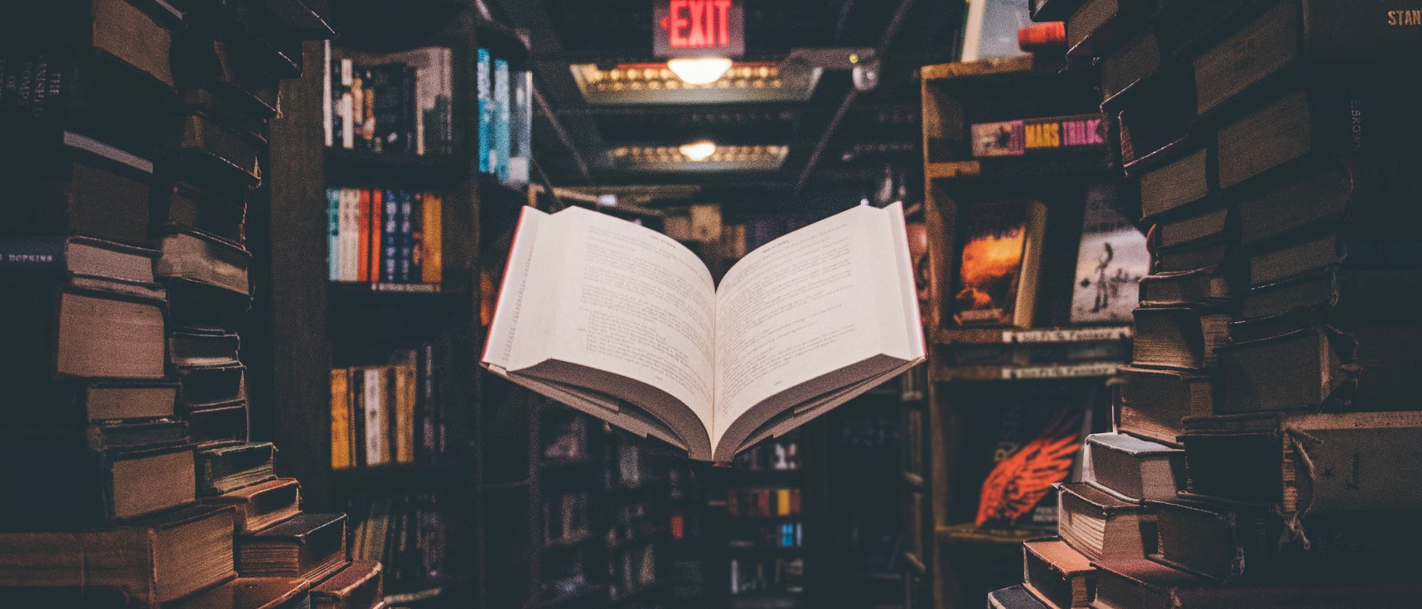 Schwebendes offenes Buch in einem Bücherfenster einer Bibliothek Schwebendes offenes Buch in einem Bücherfenster einer Bibliothek