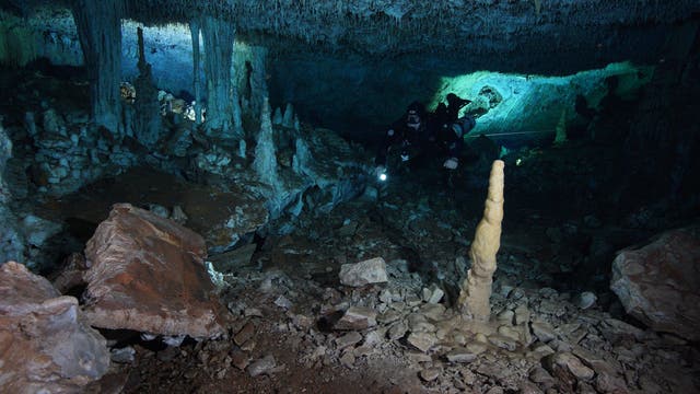 Ein Unterwasserarchäologe untersucht einen Höhlenraum, in dem einst Ocker abgebaut wurde.