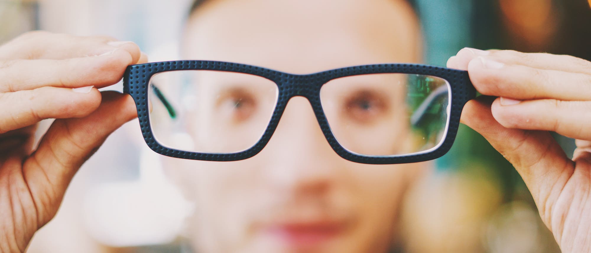 Mann hält Brille vor sich Mann hält Brille vor sich