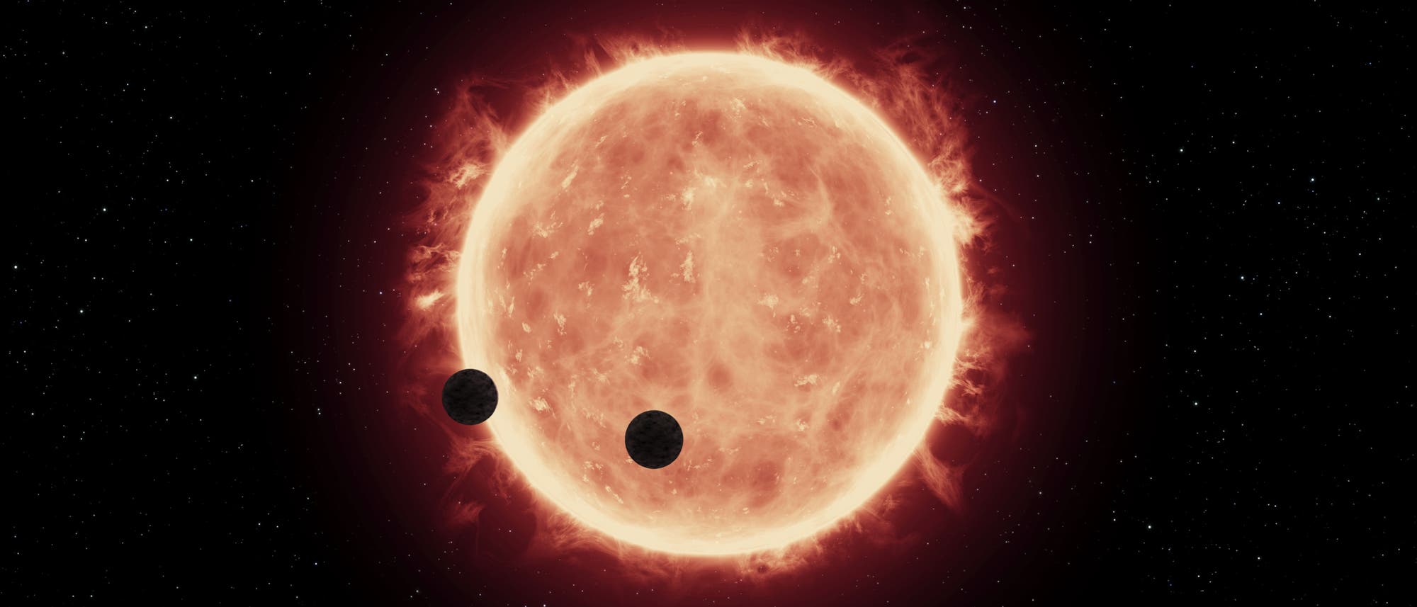 Künstlerische Darstellung von zwei Planeten von TRAPPIST-1 im Durchgang vor ihrem Stern Künstlerische Darstellung von zwei Planeten von TRAPPIST-1 im Durchgang vor ihrem Stern