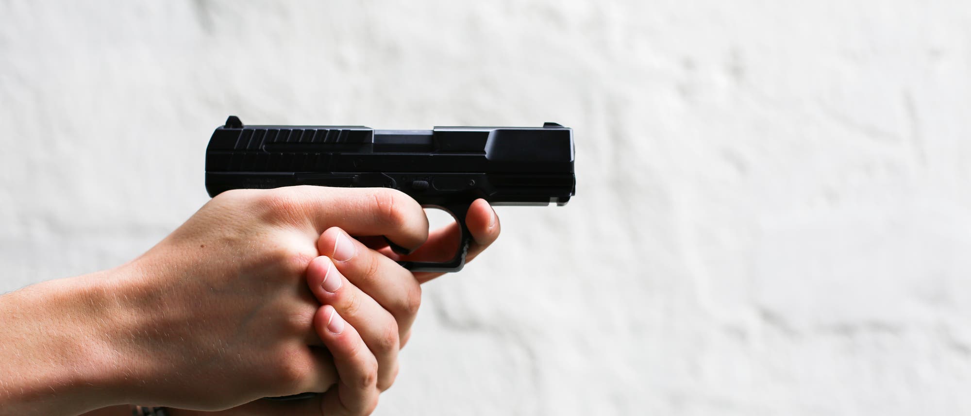 Waffe mit beiden Händen gehalten Waffe mit beiden Händen gehalten