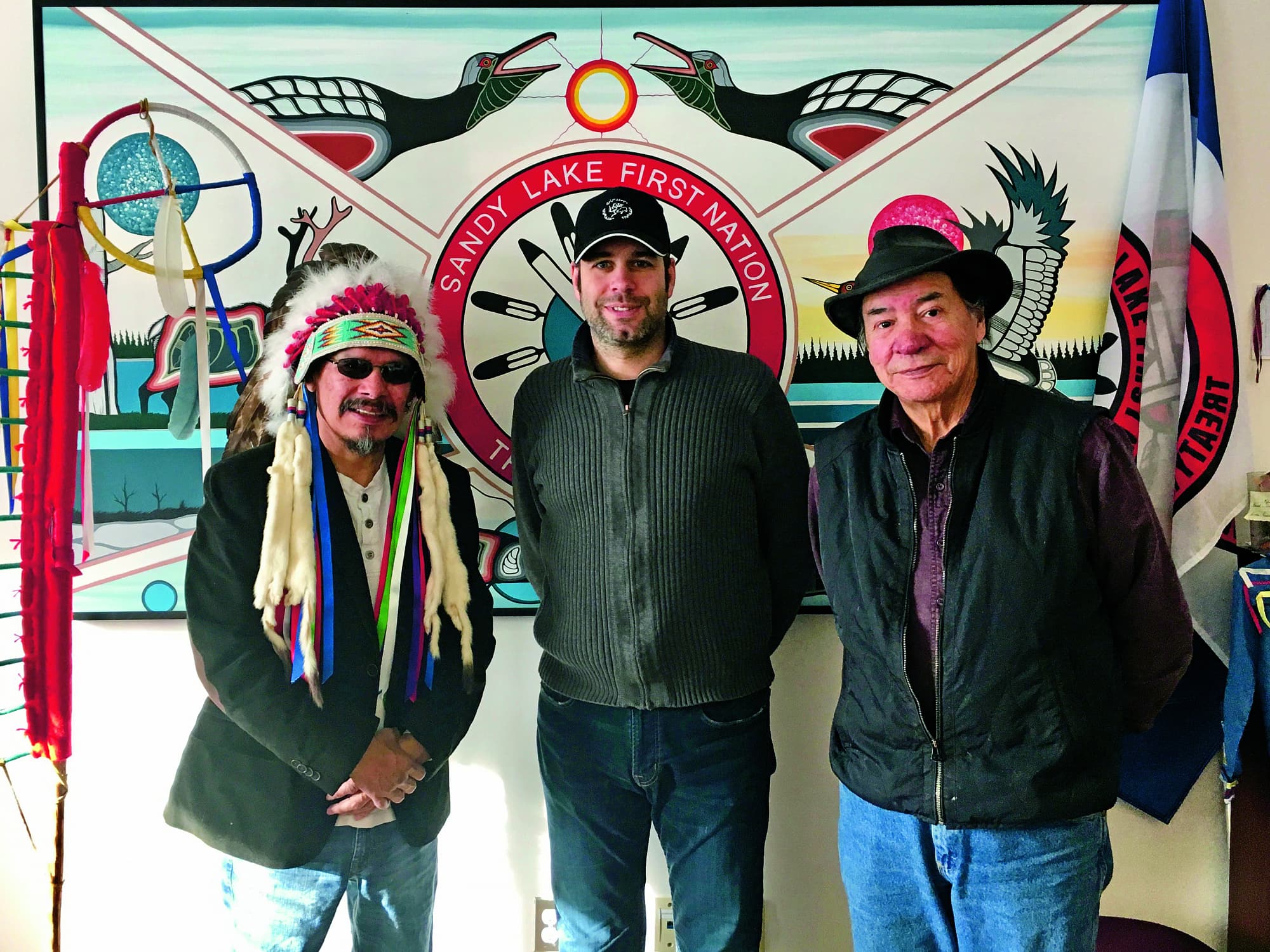 Chief Bart Meekis, Manuel Menrath (Mitte) und Deputy-Chief Robert Kakegamic im Reservat der Sandy Lake First Nation im Norden Ontarios, 2018. Das Reservat ist nur per Kleinflugzeug erreichbar, da keine Strasse hinführt. Auch von hier wurden Kinder in Hunderte Kilometer entfernte Internatsschulen verschleppt. Chief Bart Meekis, Manuel Menrath (Mitte) und Deputy-Chief Robert Kakegamic im Reservat der Sandy Lake First Nation im Norden Ontarios, 2018. Das Reservat ist nur per Kleinflugzeug erreichbar, da keine Strasse hinführt. Auch von hier wurden Kinder in Hunderte Kilometer entfernte Internatsschulen verschleppt.