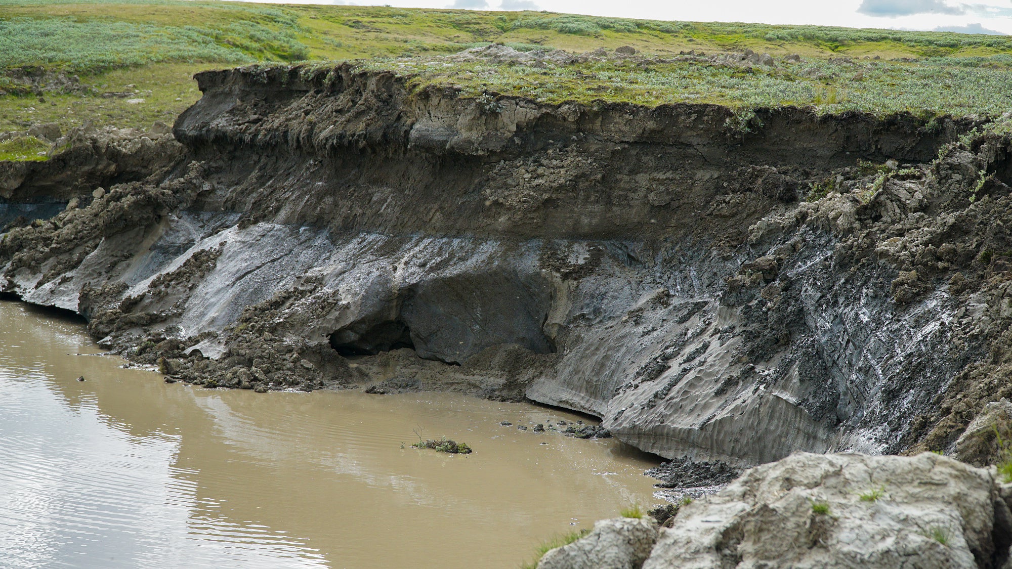 Die Steilwand eines Kraters in Sibirien, der vermutlich von einer geschmolzenen Eislinse hinterlassen wurde. In der Steilwand erkennt man noch die Permafrost-Schichten. Die Steilwand eines Kraters in Sibirien, der vermutlich von einer geschmolzenen Eislinse hinterlassen wurde. In der Steilwand erkennt man noch die Permafrost-Schichten.