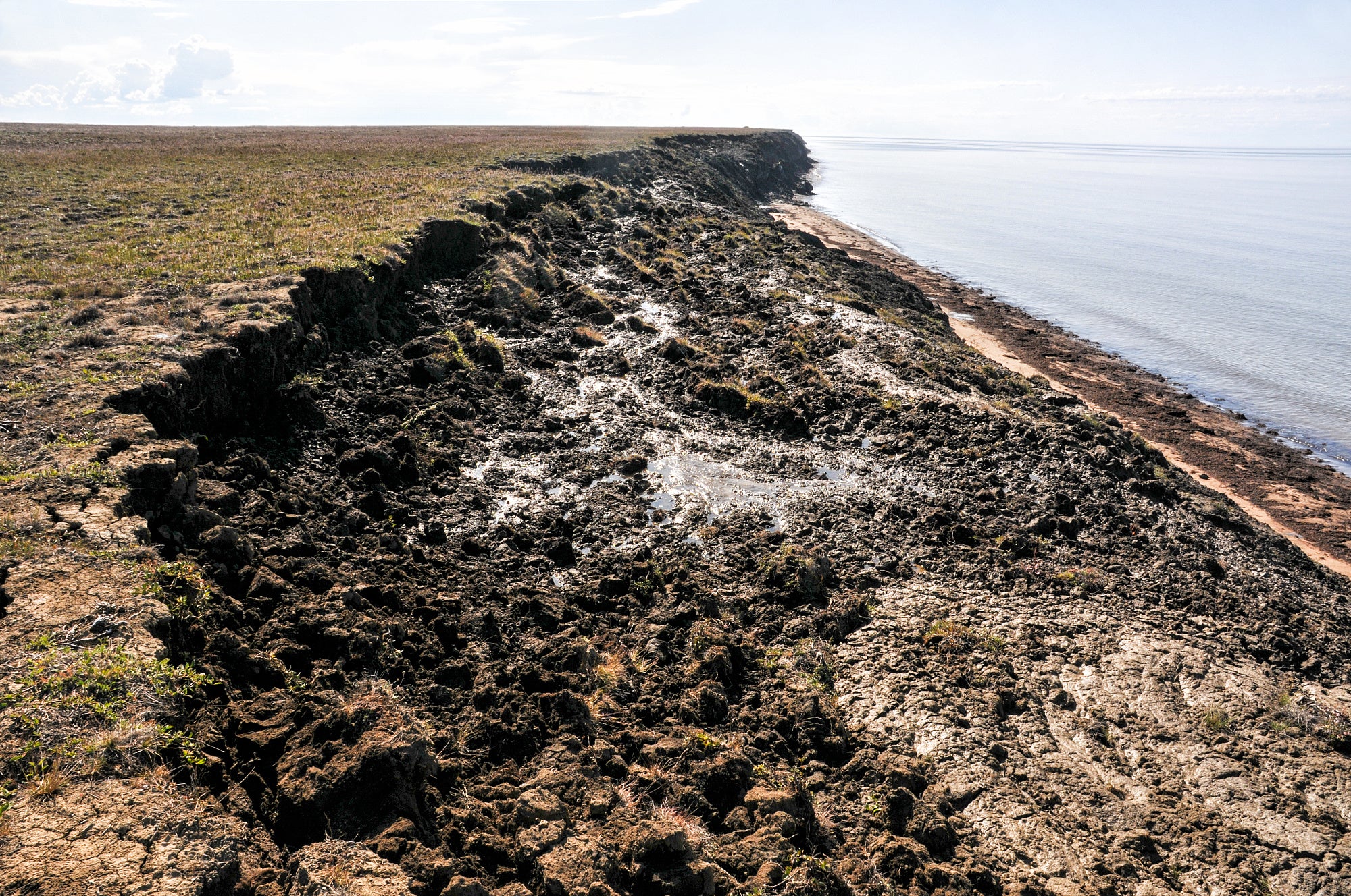 Flache Tundra, die entlang der ganzen Uferlinie ins Meer abrutscht. Flache Tundra, die entlang der ganzen Uferlinie ins Meer abrutscht.