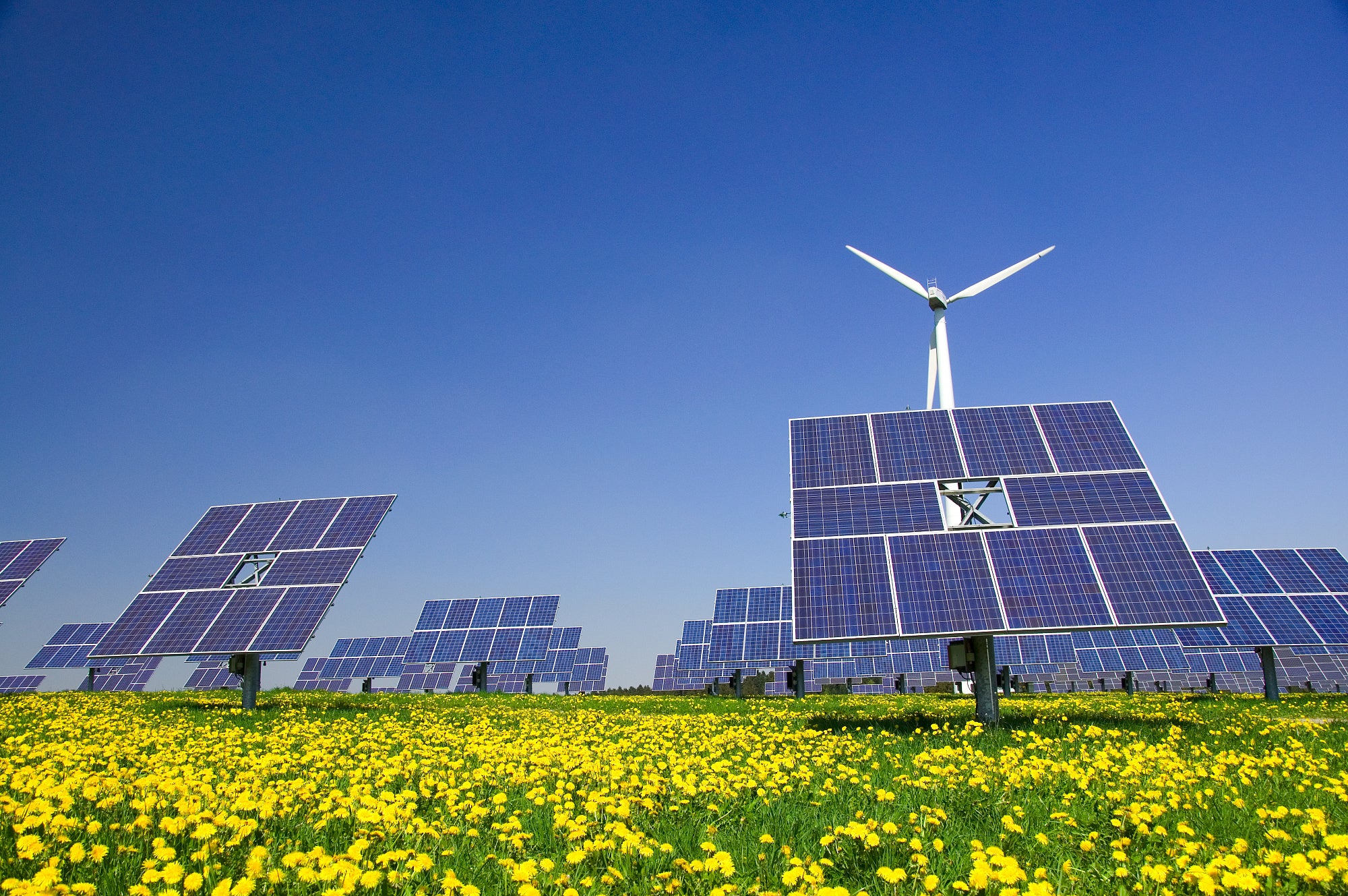 Windrad und Solarzellen ergänzen sich auf einer Wiese Windrad und Solarzellen ergänzen sich auf einer Wiese