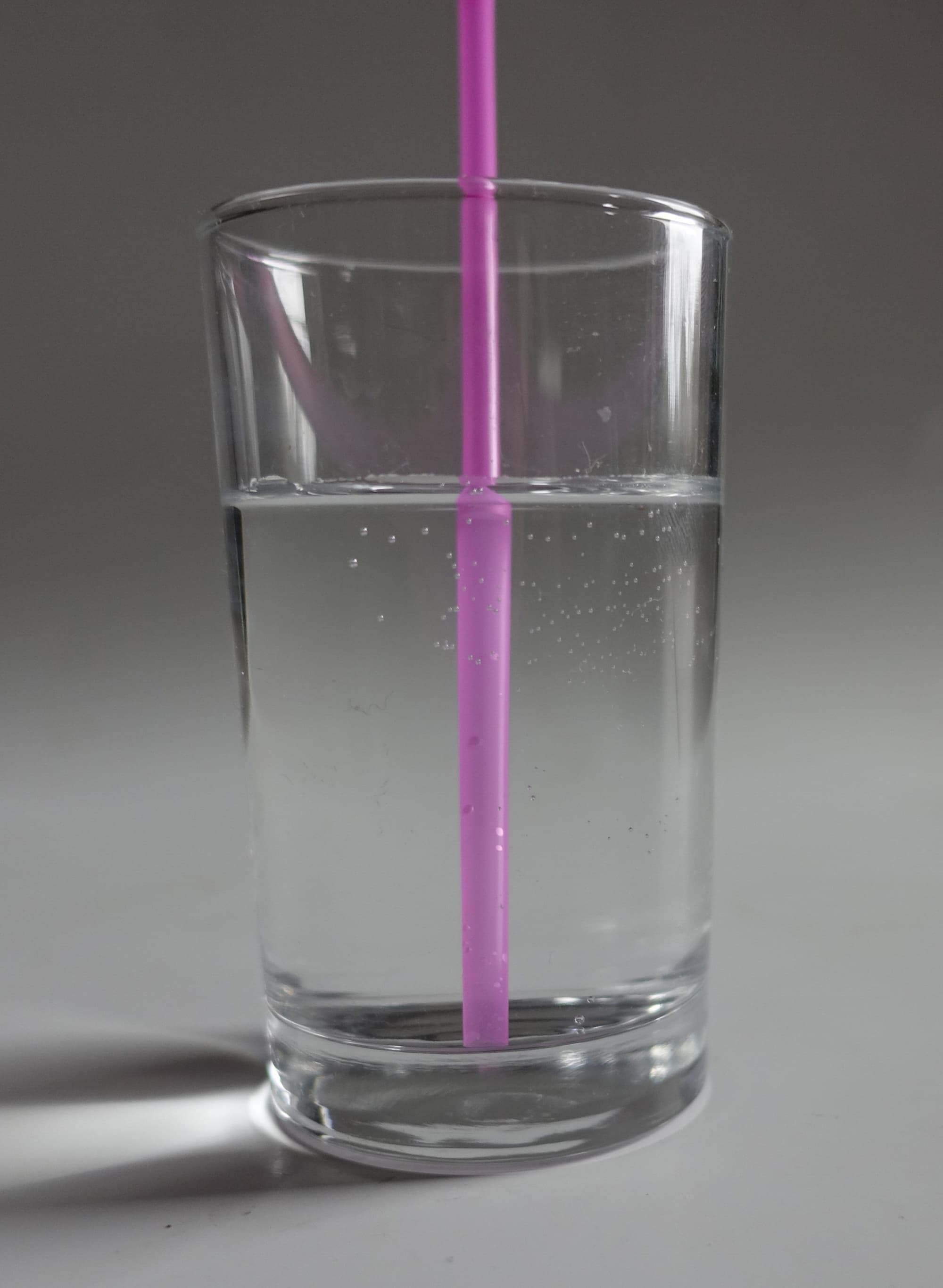 Glas Wasser mit Trinkhalm Glas Wasser mit Trinkhalm