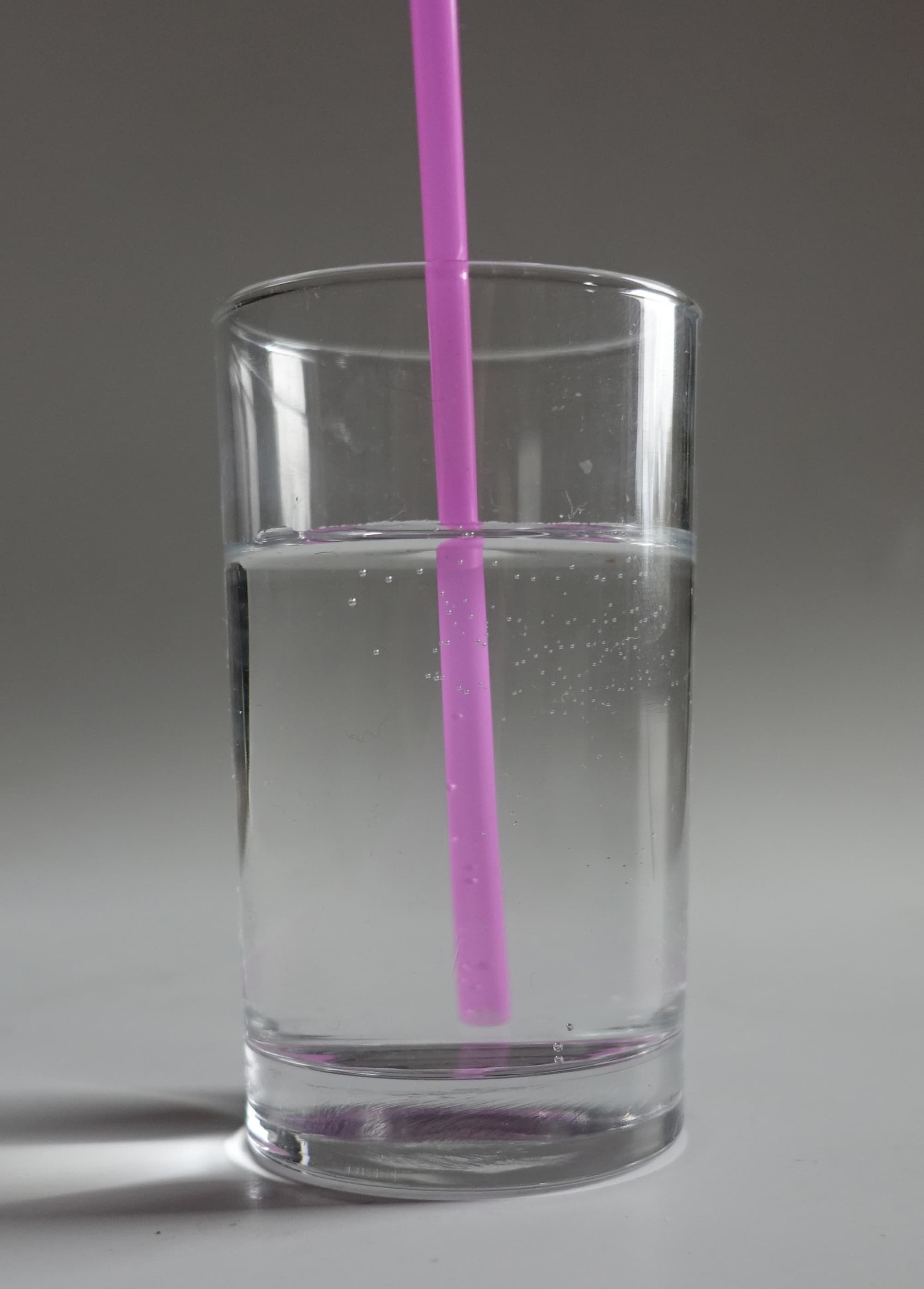 Glas Wasser mit Trinkhalm Glas Wasser mit Trinkhalm