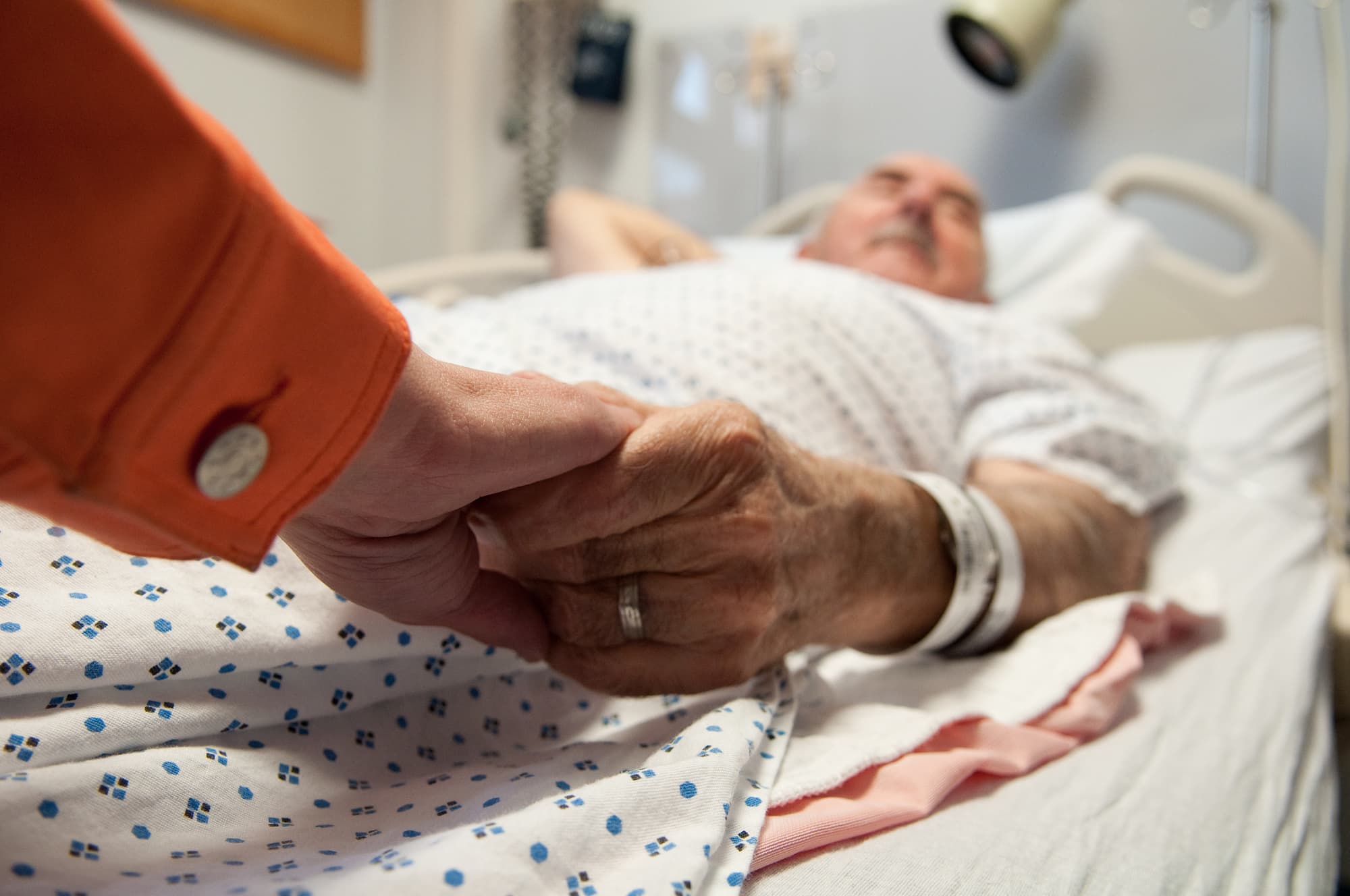 Frau hält sterbendem Mann die Hand Frau hält sterbendem Mann die Hand