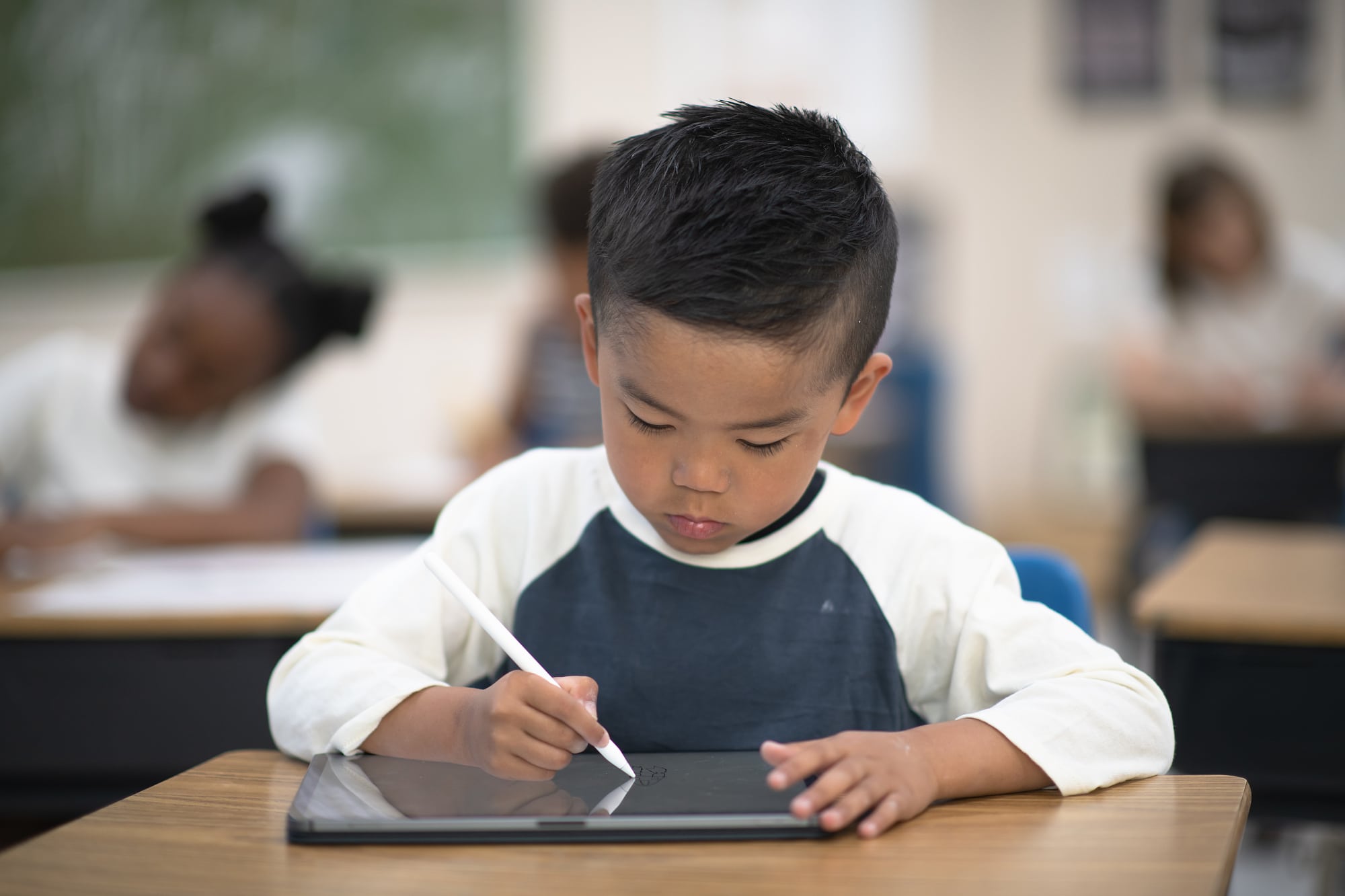 Junge schreibt auf Tablet Junge schreibt auf Tablet