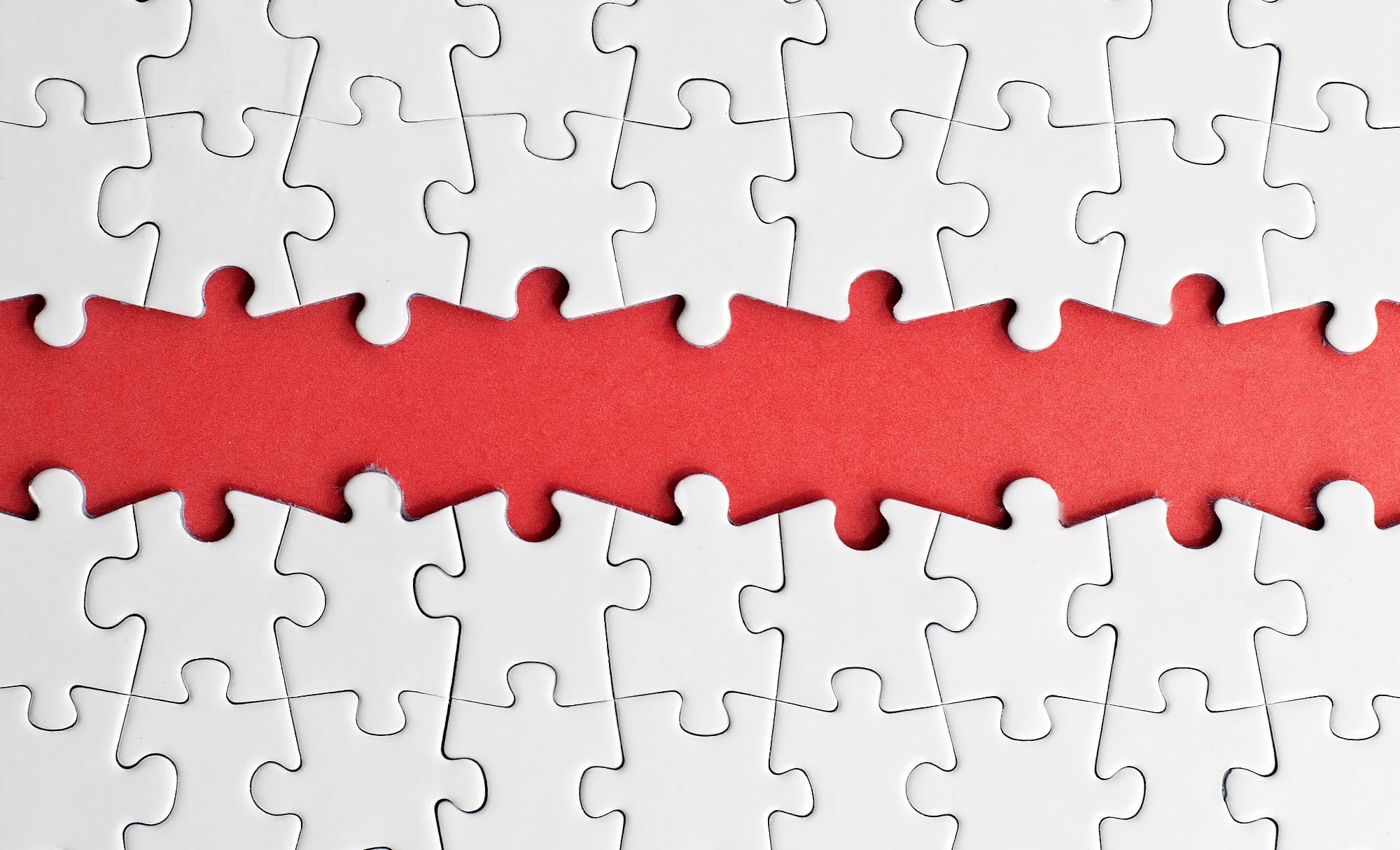In einem Puzzle fehlt eine ganze Reihe von Teilen In einem Puzzle fehlt eine ganze Reihe von Teilen