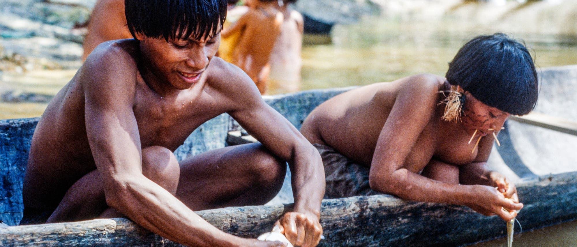 Yanomami säubern Fische am Flussufer Yanomami säubern Fische am Flussufer